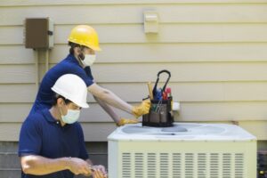 two-technicians-working-on-outside-ac-unit