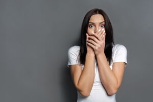 woman-looking-shocked-with-hands-covering-mouth