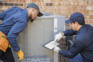 two-technicians-outside-working-carefully-on-ac-unit