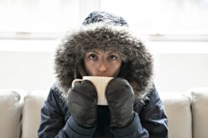 cold-person-wearing-coat-and-mittens-indoors