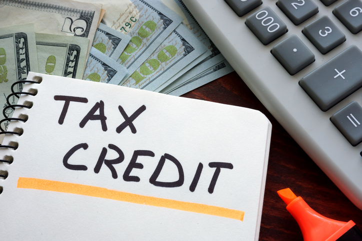 Tax Credit Calculation: Financial Planning with Money, Calculator, and Notebook