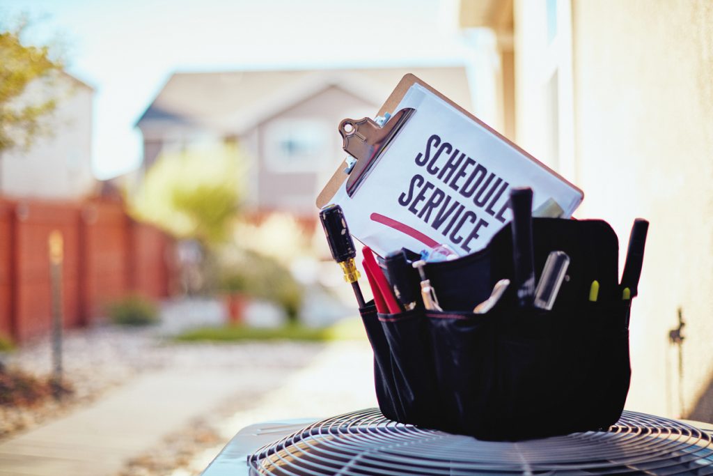 Air conditioner with maintenance tools and service reminder in residential back yard